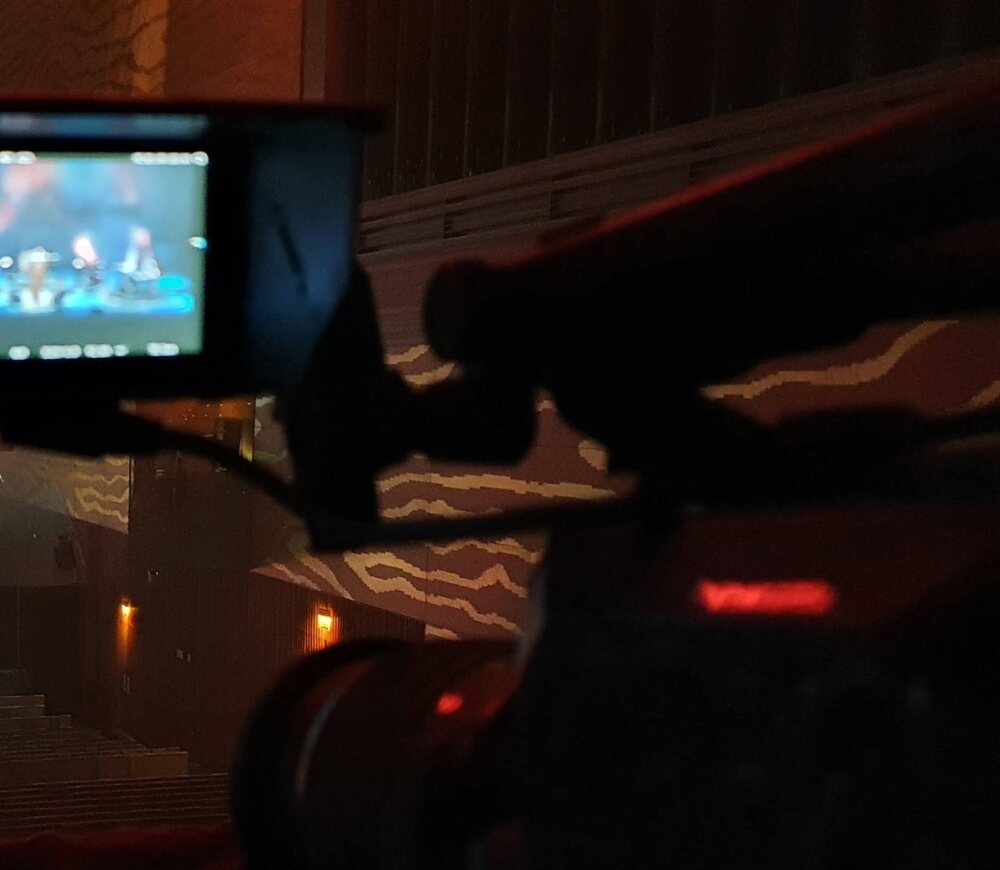 Câmera apontada para uma apresentação em palco